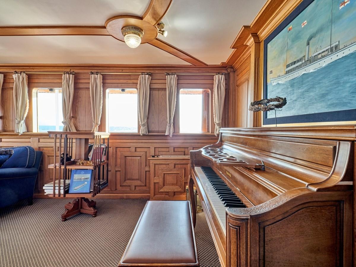 a room with a piano and a couch aboard MADIZ Yacht for Sale