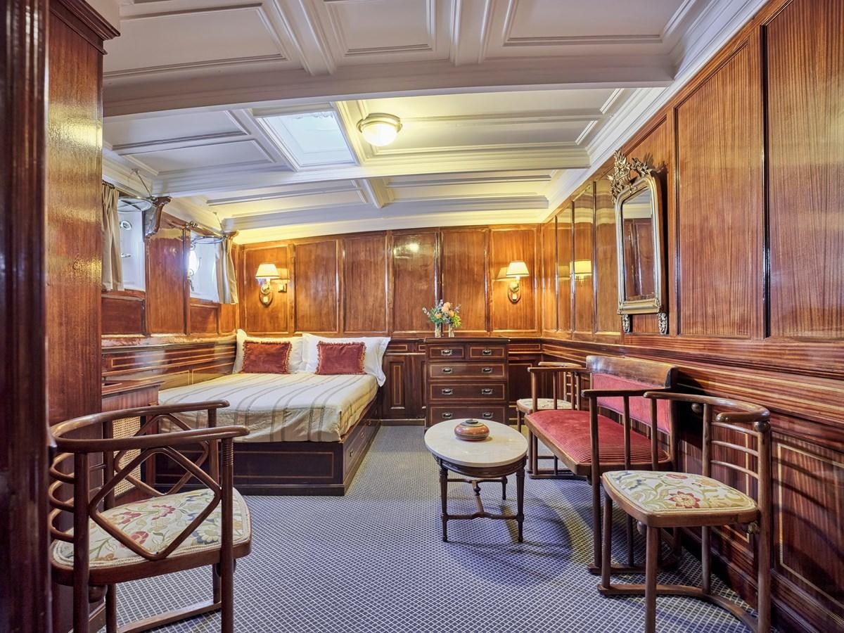 a bedroom with a bed and a table aboard MADIZ Yacht for Sale