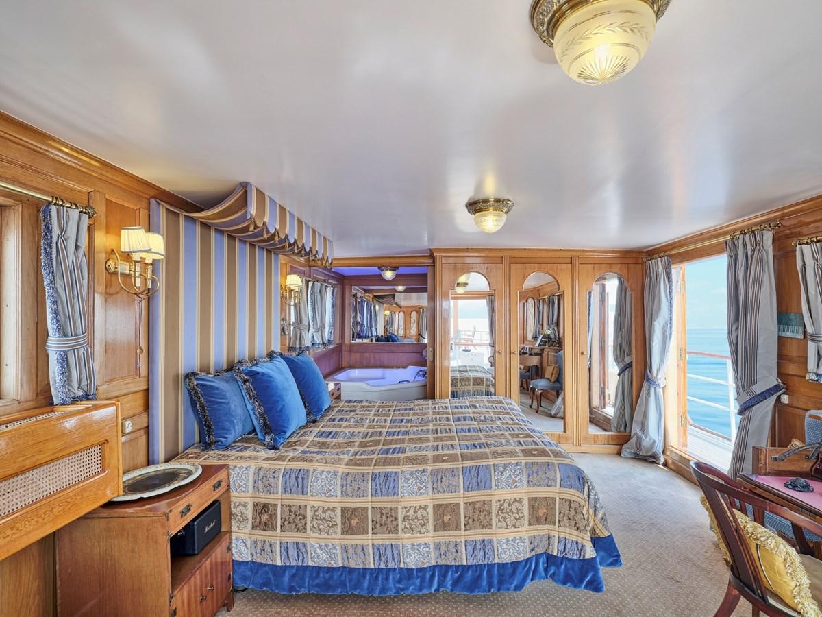 a bedroom with a bed and a desk aboard MADIZ Yacht for Sale