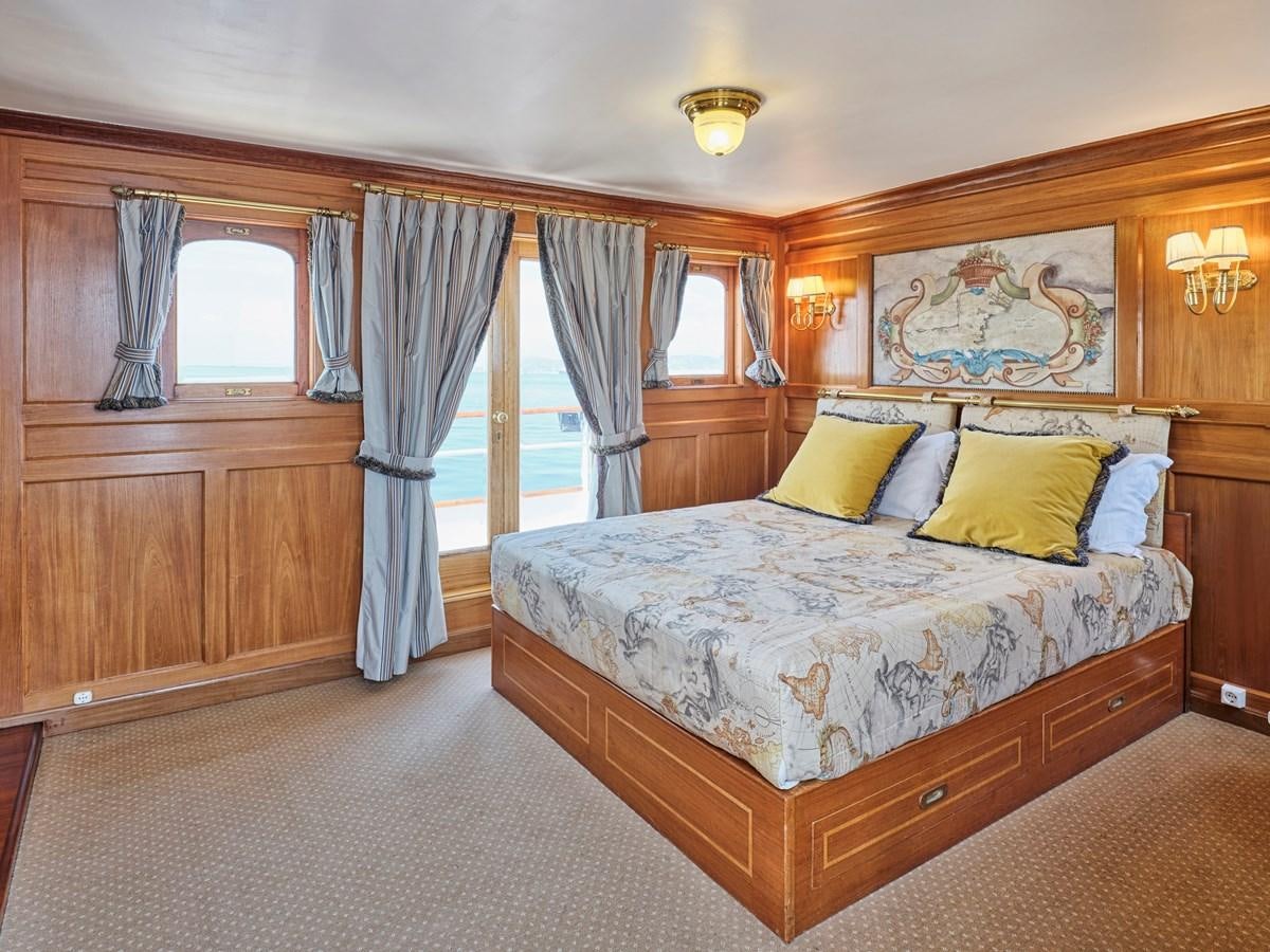 a bedroom with a bed and a window aboard MADIZ Yacht for Sale