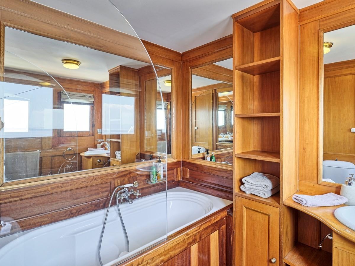 a bathroom with a tub sink and mirror aboard MADIZ Yacht for Sale