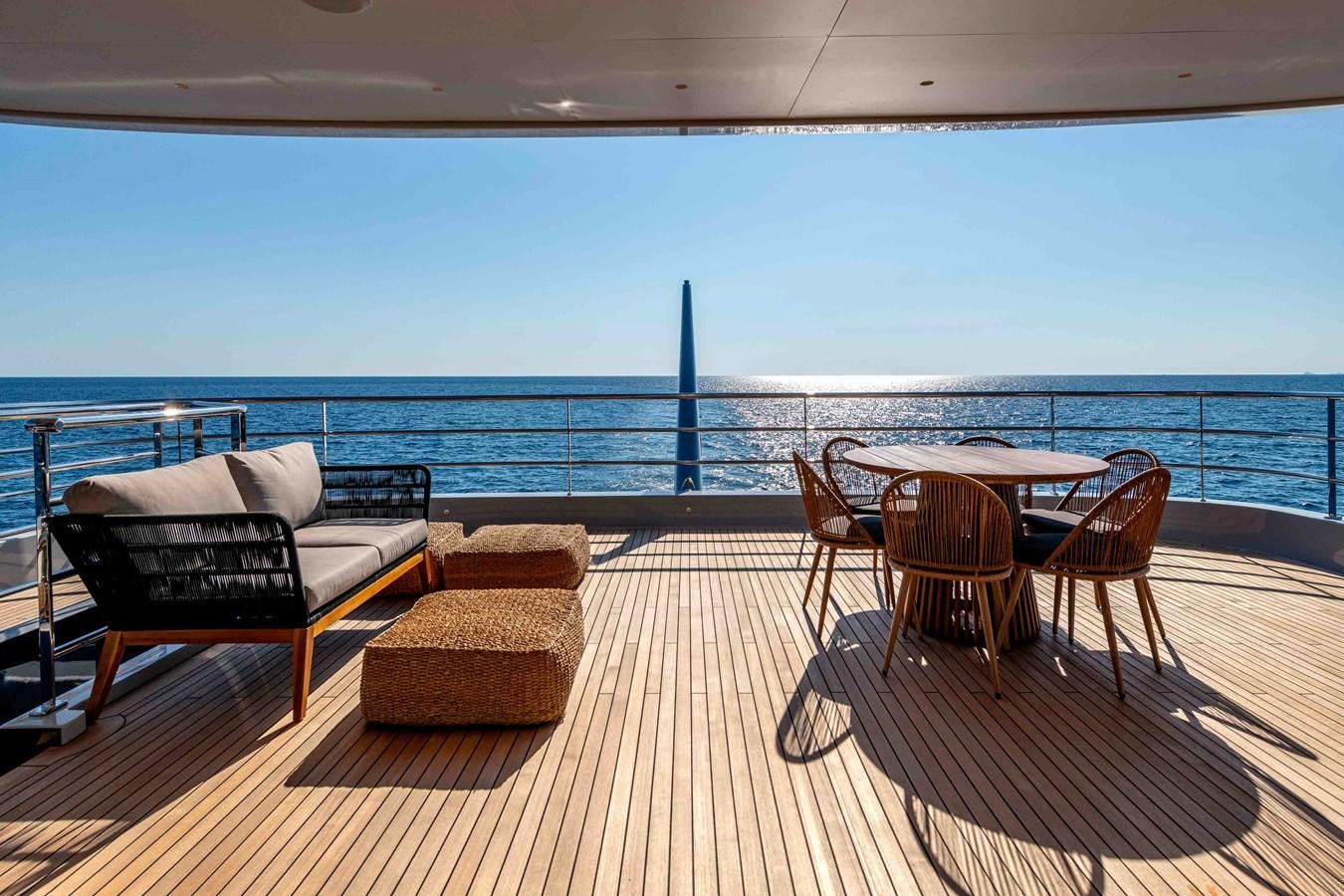 a deck with chairs and a table on it aboard MISS CANDY Yacht for Sale
