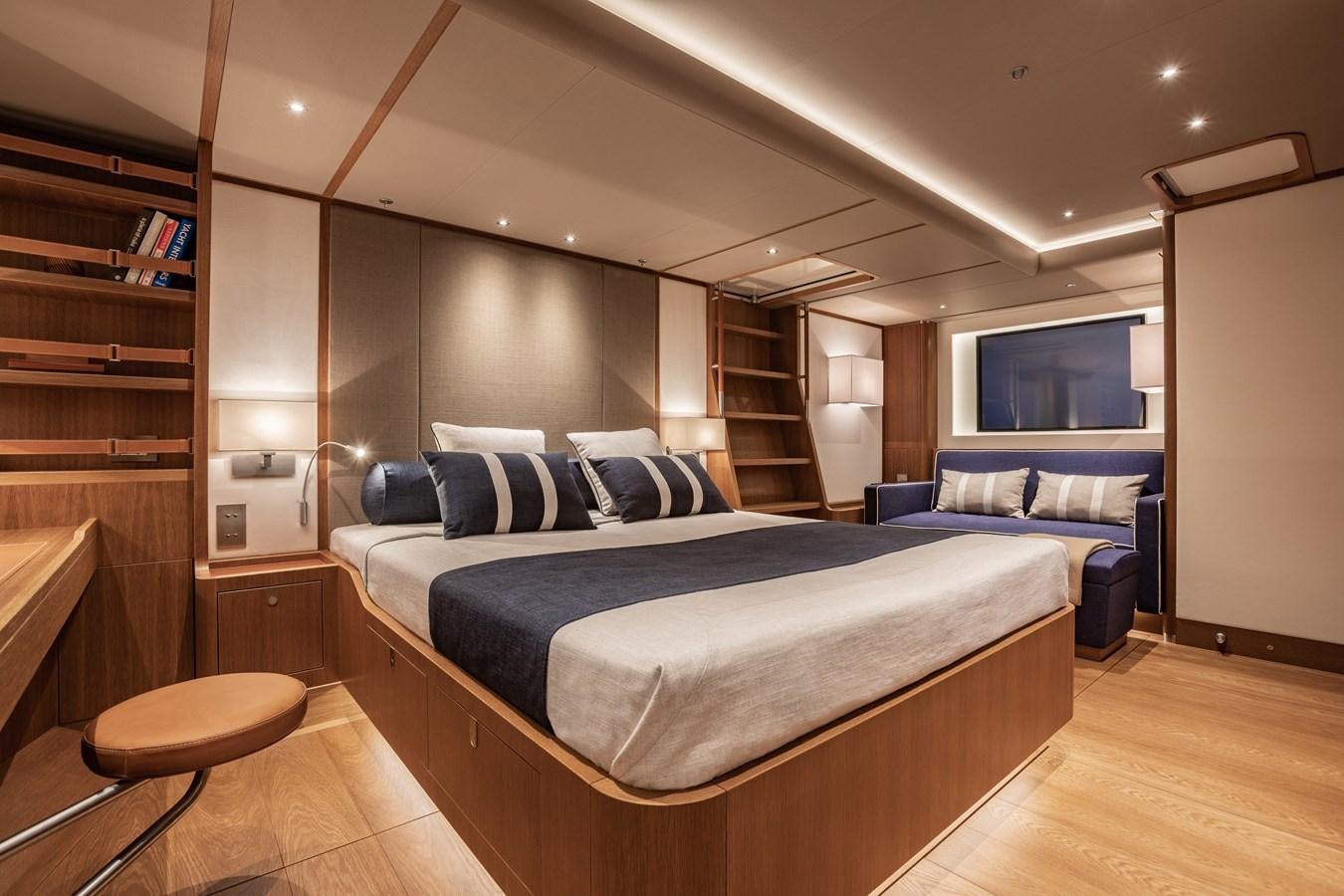 a bedroom with a bed and a bookcase aboard HONEY RYDER Yacht for Sale