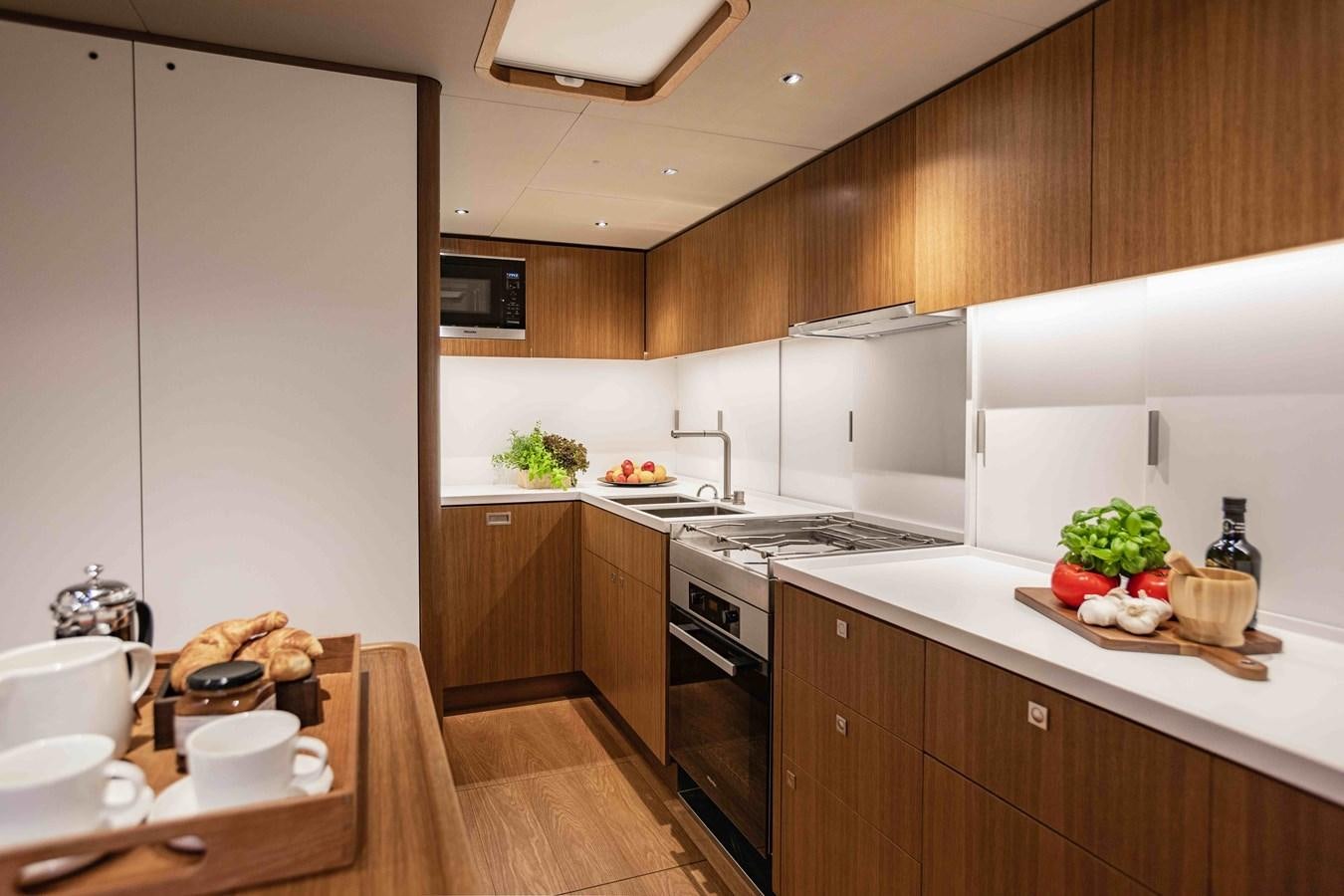 a kitchen with a table and a stove aboard HONEY RYDER Yacht for Sale