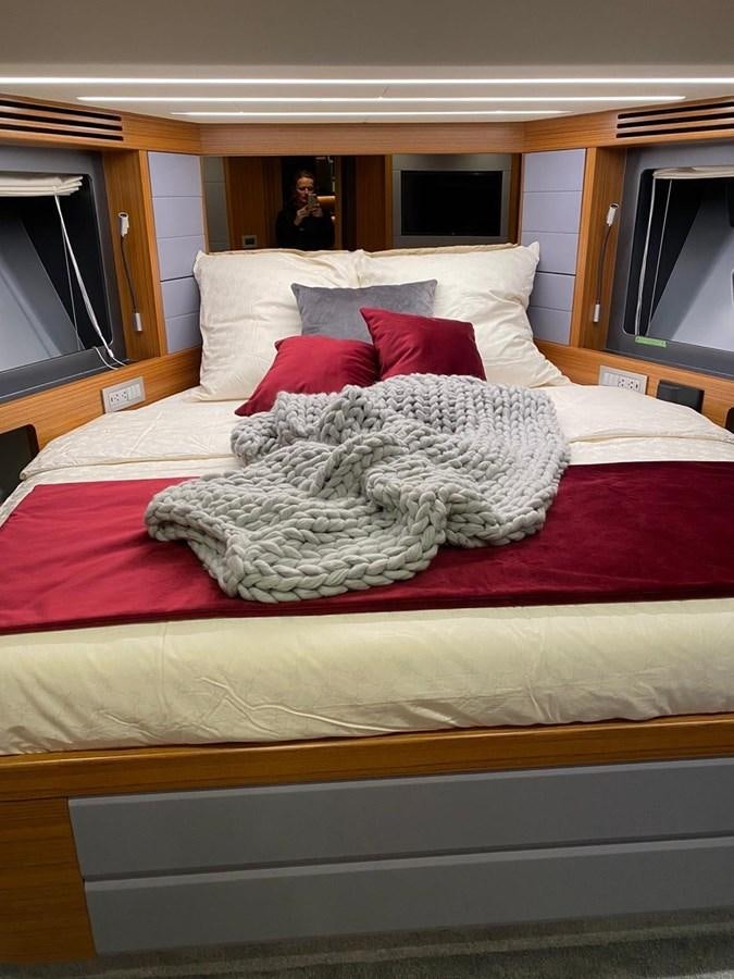 a bed with a red blanket aboard OCEAN CLASS 68 Yacht for Sale
