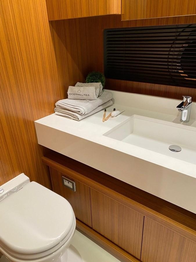 a bathroom with a toilet and a sink aboard OCEAN CLASS 68 Yacht for Sale
