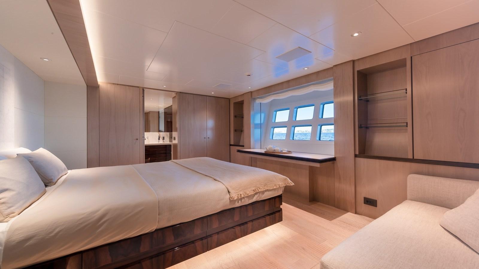a room with a bed and a desk aboard OCEANIC GRAND Yacht for Sale