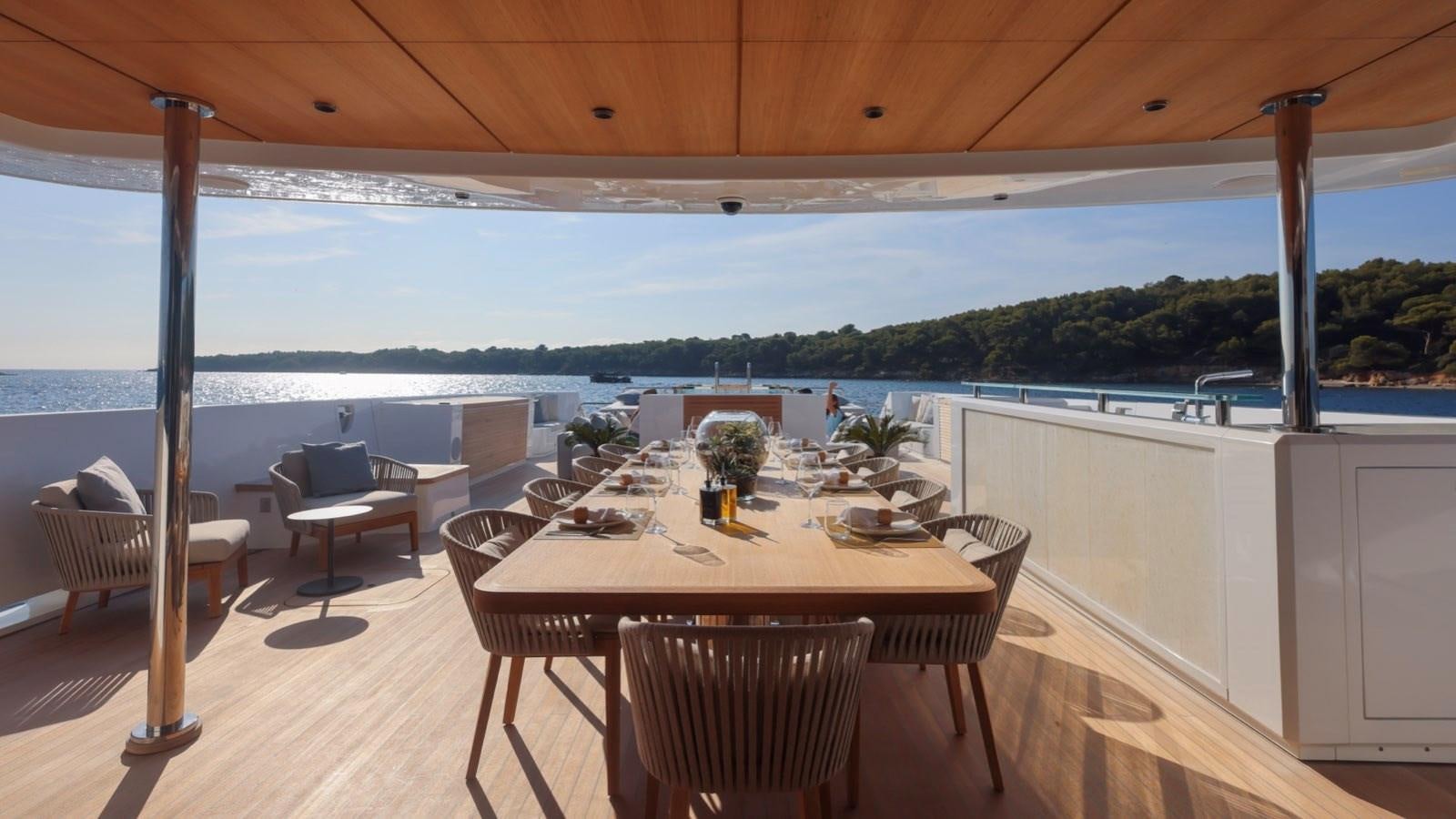 a table and chairs on a deck aboard OCEANIC GRAND Yacht for Sale