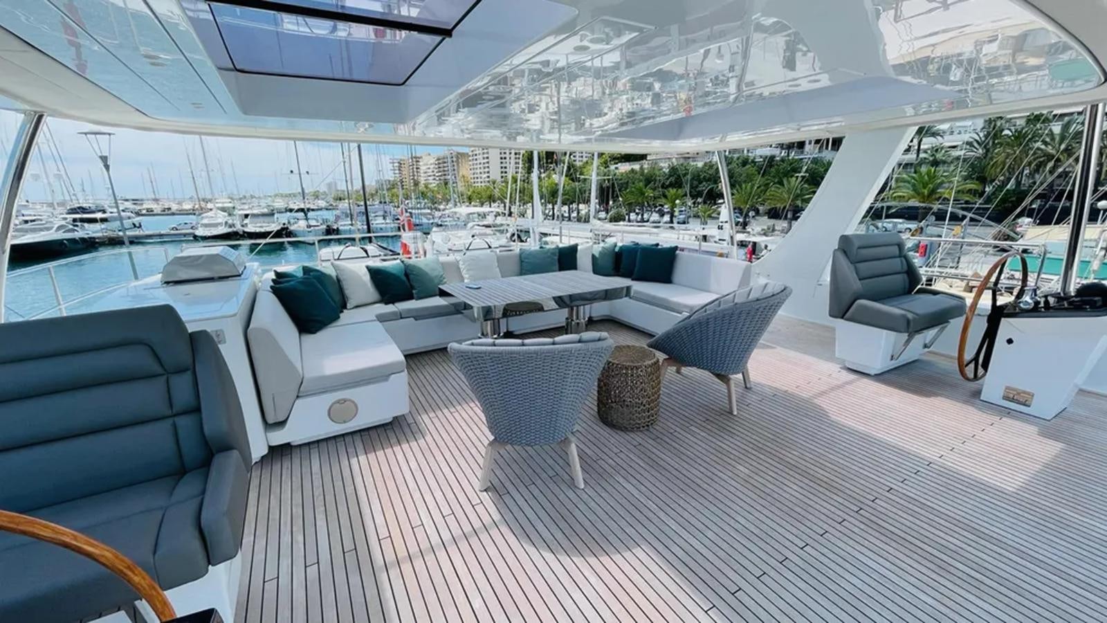 a large lounge area with a large white lounge chair and a table with a large white and blue aboard SEACLUSION Yacht for Sale