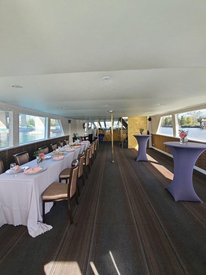 a dining room with a large window aboard 1990 PALMER MARINE 68 Yacht for Sale