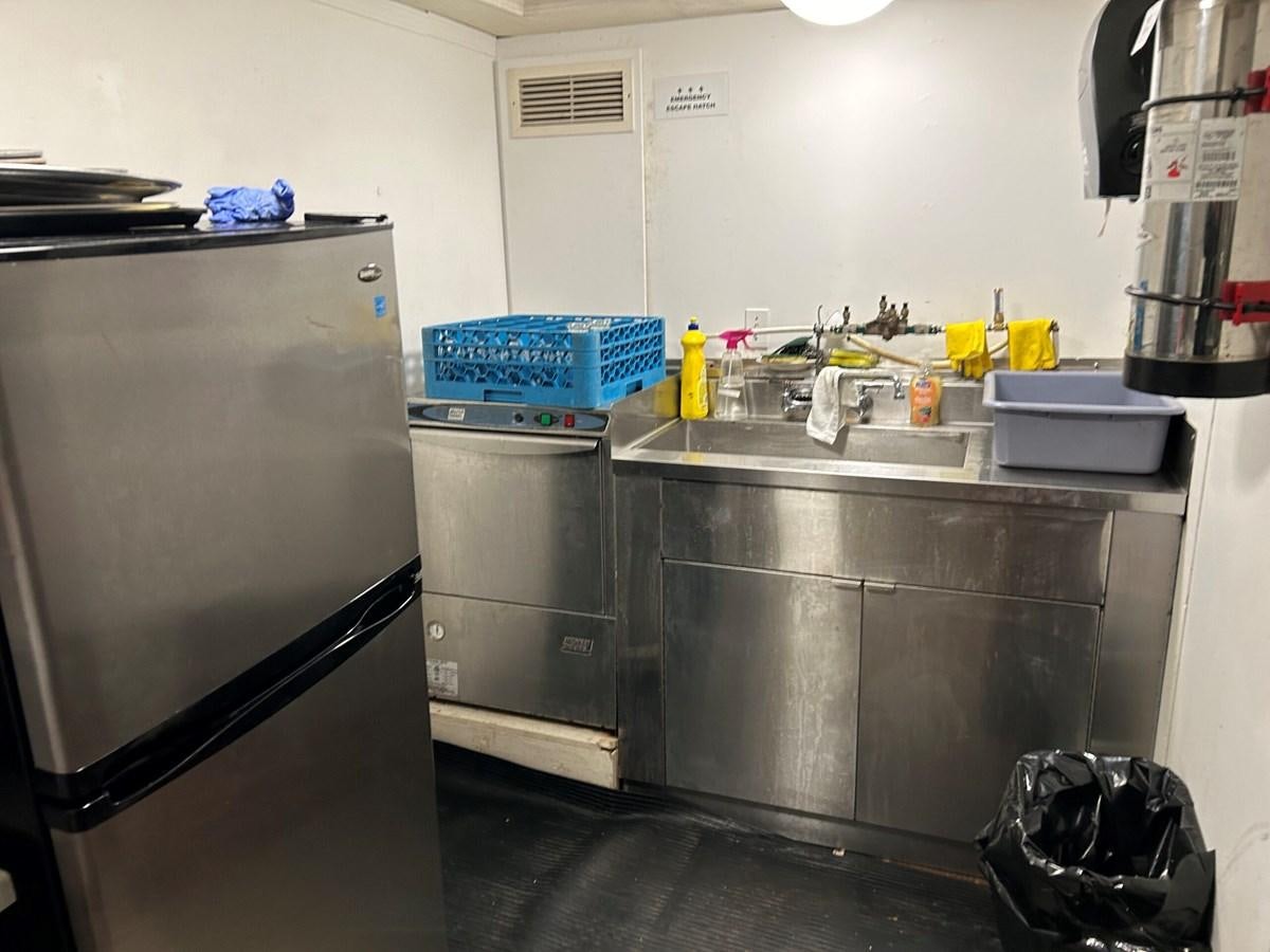 a kitchen with stainless steel appliances aboard 1990 PALMER MARINE 68 Yacht for Sale