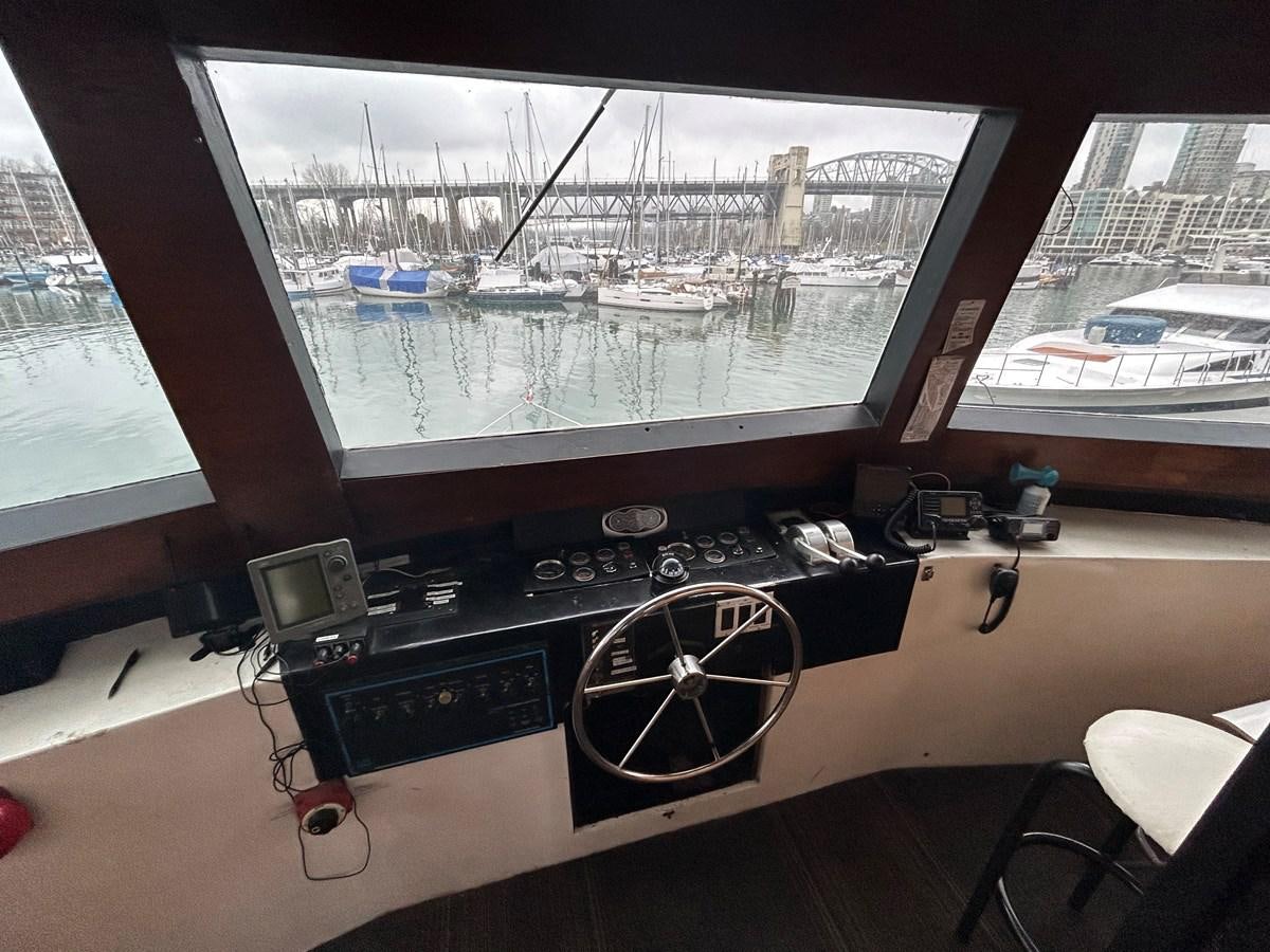 a black and white video game console in front of a window with a cityscape and boats aboard 1990 PALMER MARINE 68 Yacht for Sale