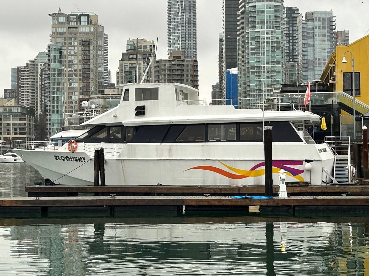 a white and black boat on a dock in a city aboard 1990 PALMER MARINE 68 Yacht for Sale