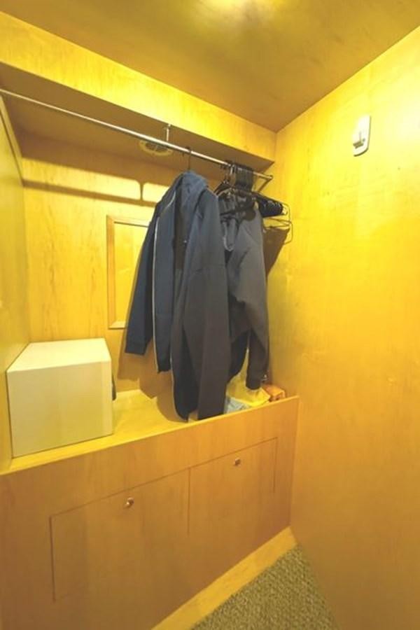 a closet with clothes on the wall aboard CLASSIFIED Yacht for Sale