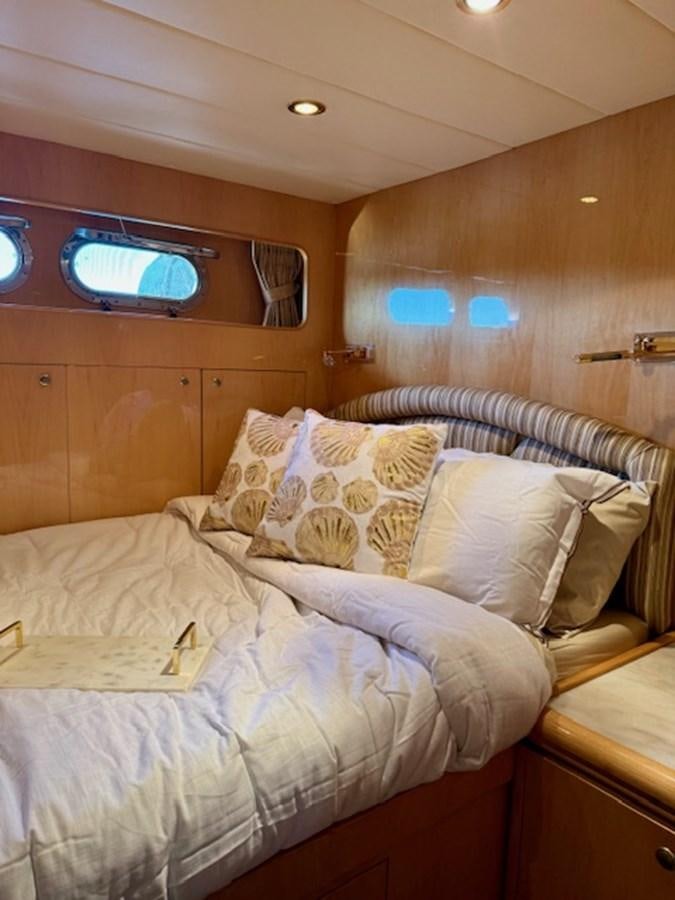 a bed with white sheets aboard CLASSIFIED Yacht for Sale