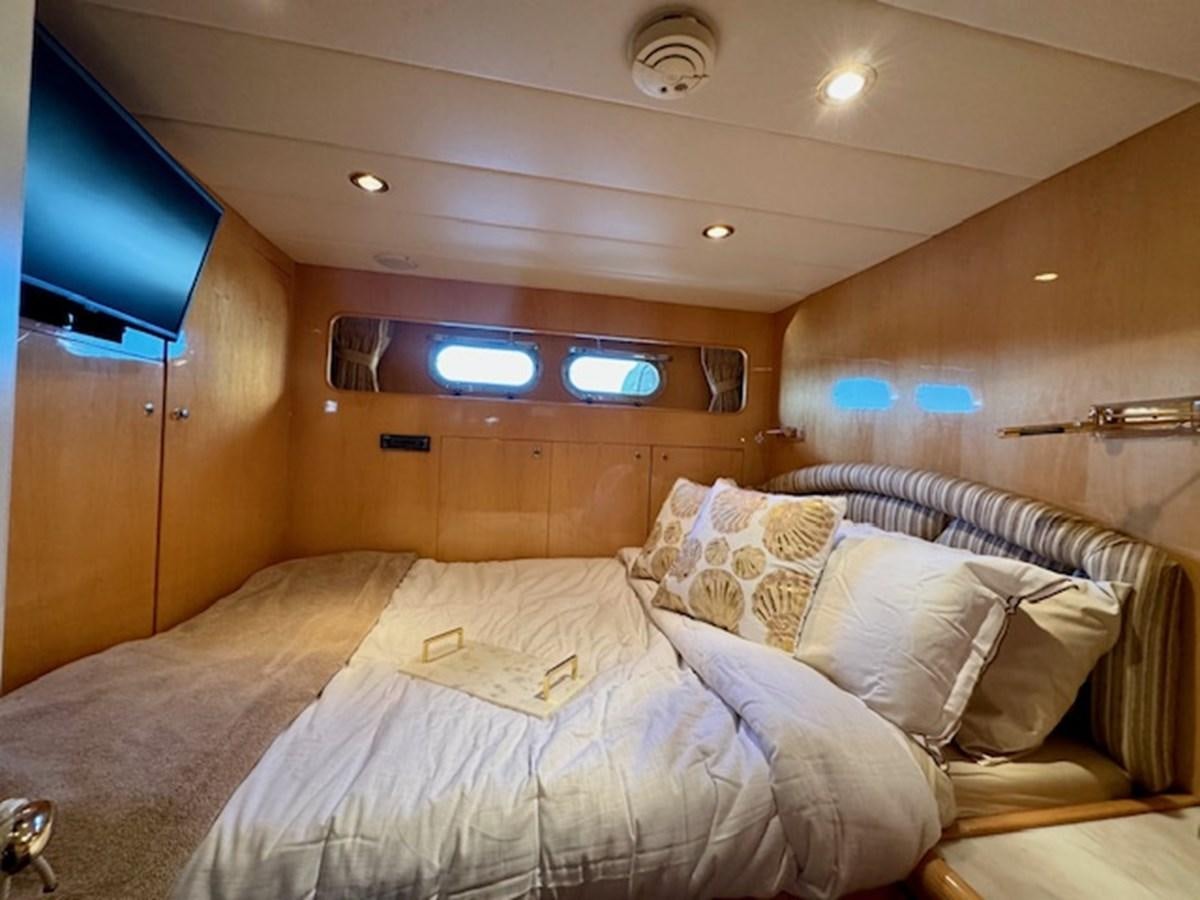 a room with a bed and a tv on the wall aboard CLASSIFIED Yacht for Sale