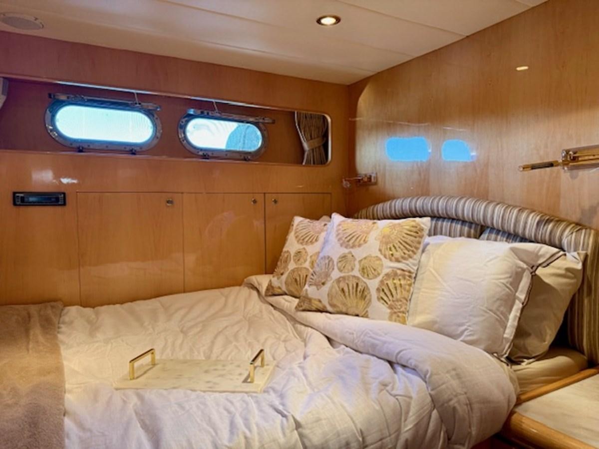 a bed with a bed and a television on the wall aboard CLASSIFIED Yacht for Sale