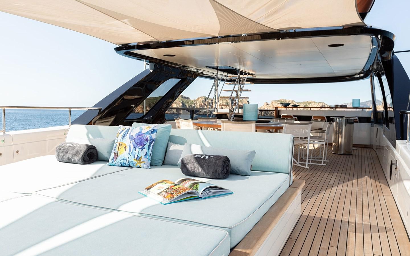 a large white lounge chair on a deck with a large white table and a large white table with aboard EH2 Yacht for Sale