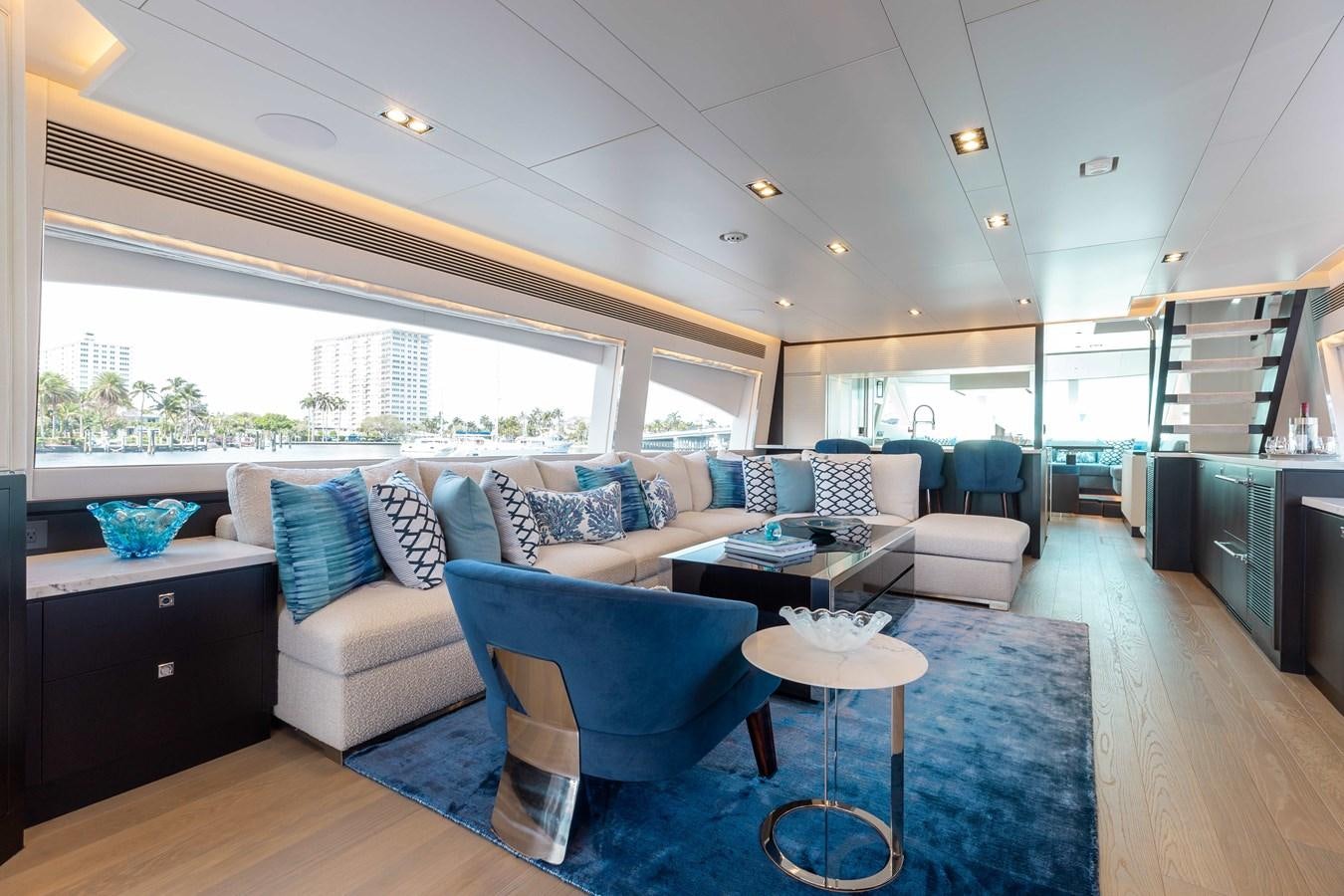 a living room with a blue chair and a table aboard E90 MOTOR Yacht for Sale