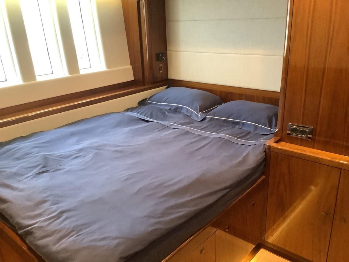 a bed with a blue comforter aboard GUARDIAN ANGEL Yacht for Sale