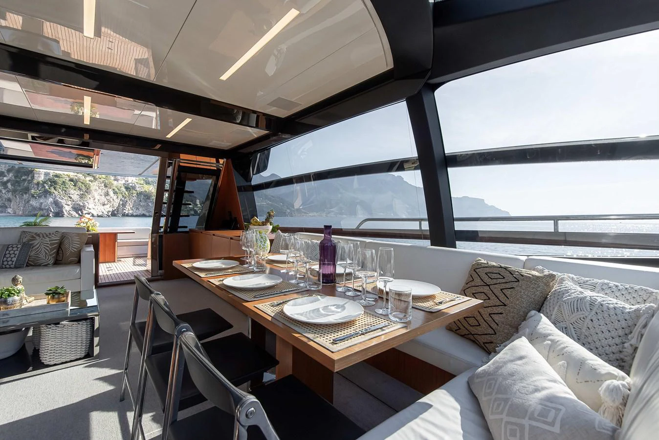 a table with a glass bottle on it and a couch in the background aboard SOUL Yacht for Sale