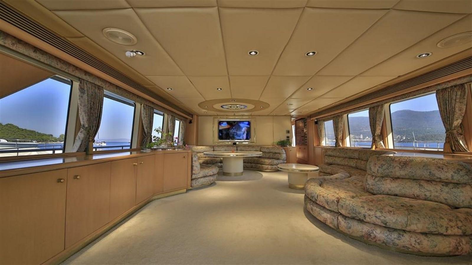 a room with a couch and a tv on the wall aboard AGARTHA Yacht for Sale
