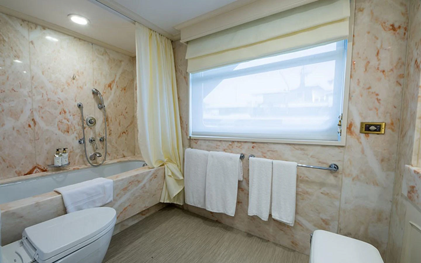a bathroom with a tub sink and toilet aboard NOSTALGIA Yacht for Sale