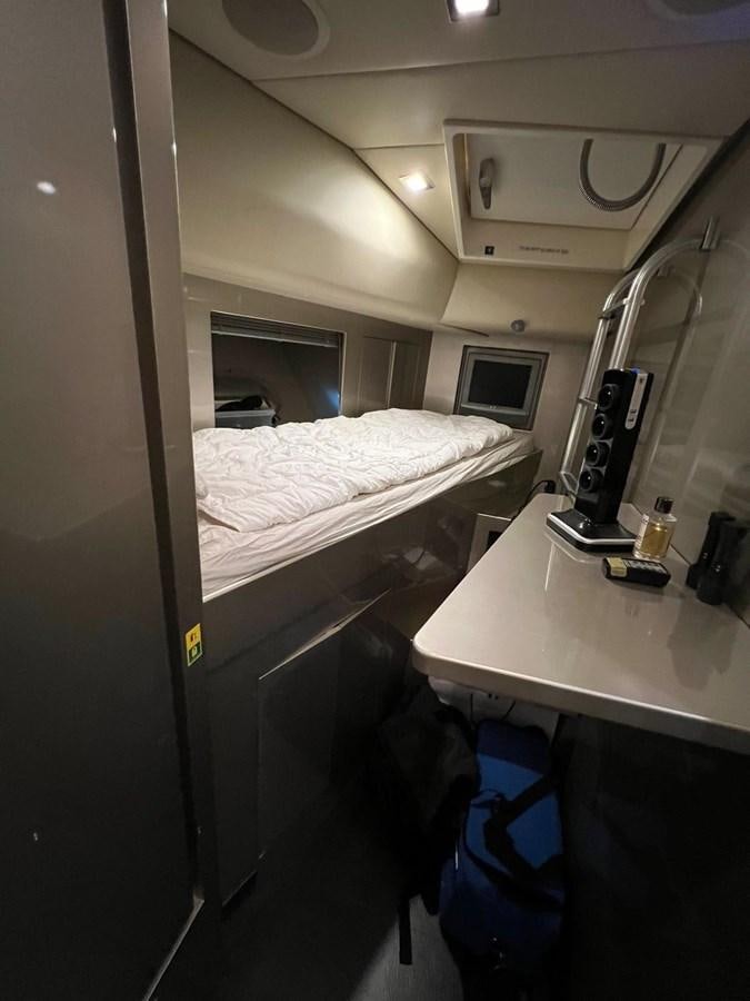 a small room with a bed and desk aboard SAGA ONE Yacht for Sale