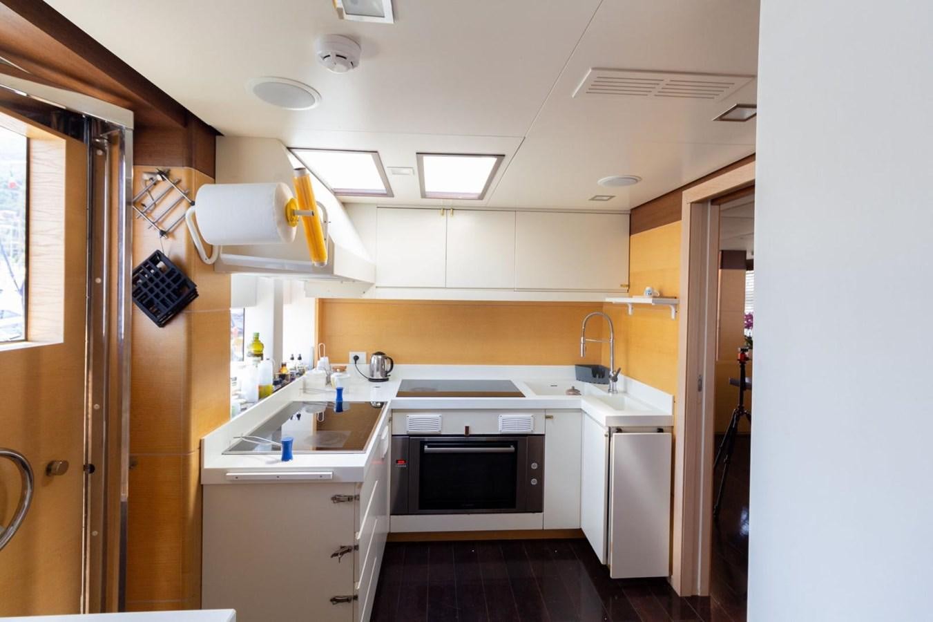 a kitchen with white cabinets aboard MR GU Yacht for Sale