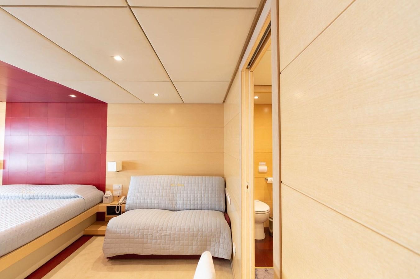a bedroom with a bed and a pink wall aboard MR GU Yacht for Sale