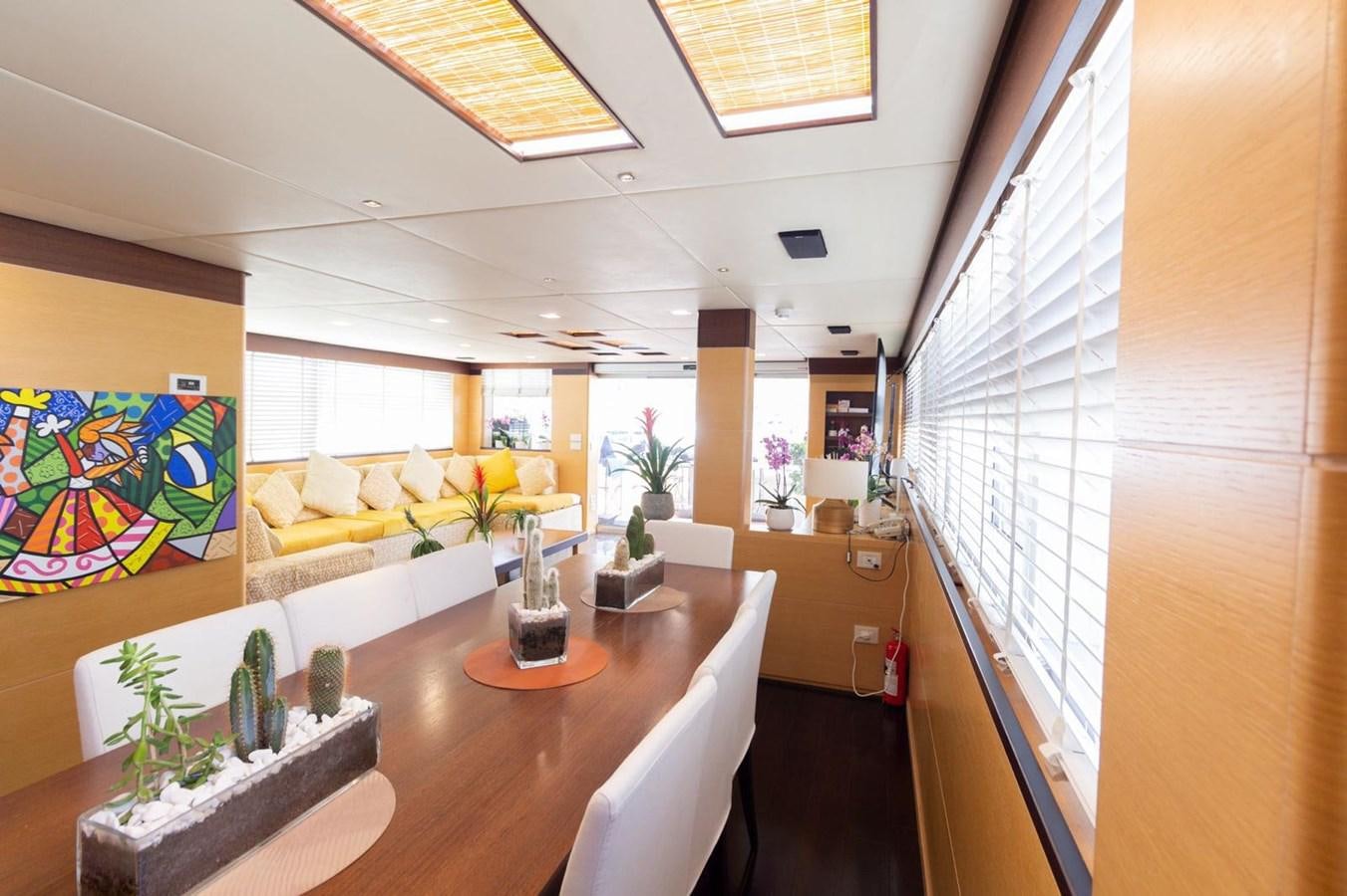 a room with a table and chairs aboard MR GU Yacht for Sale