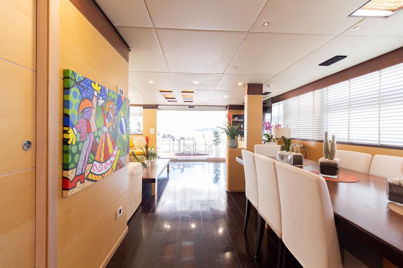 a room with tables and chairs aboard MR GU Yacht for Sale