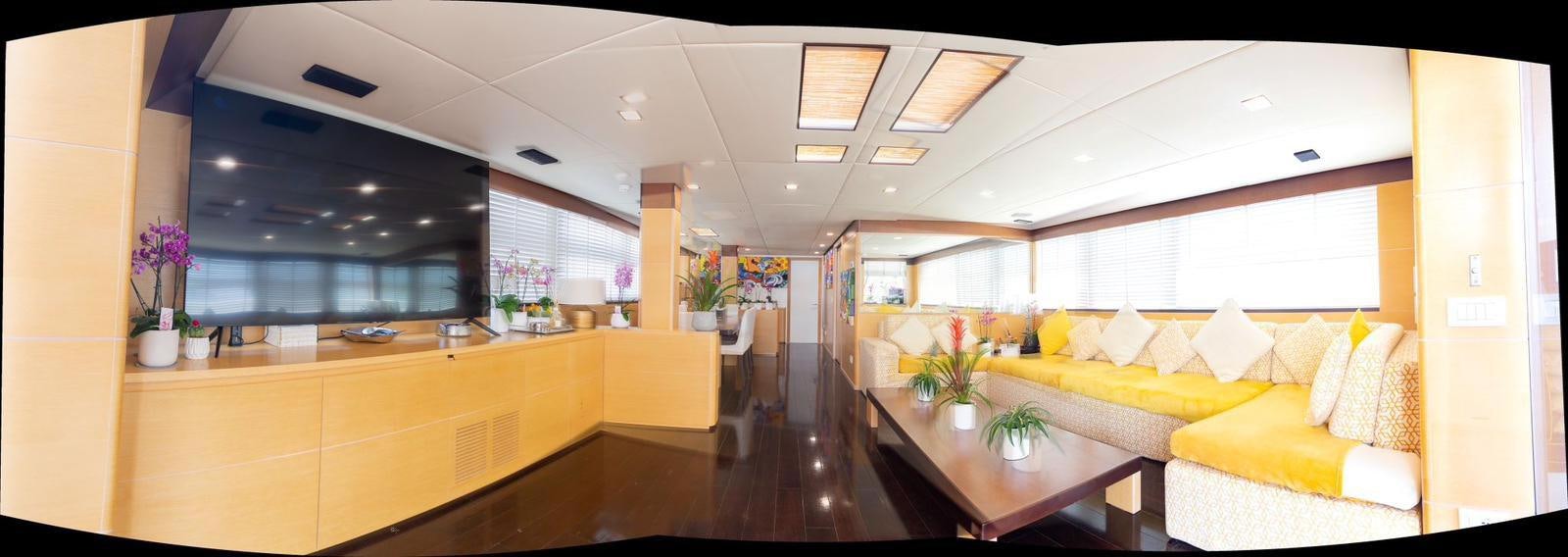 a room with a table and couches aboard MR GU Yacht for Sale