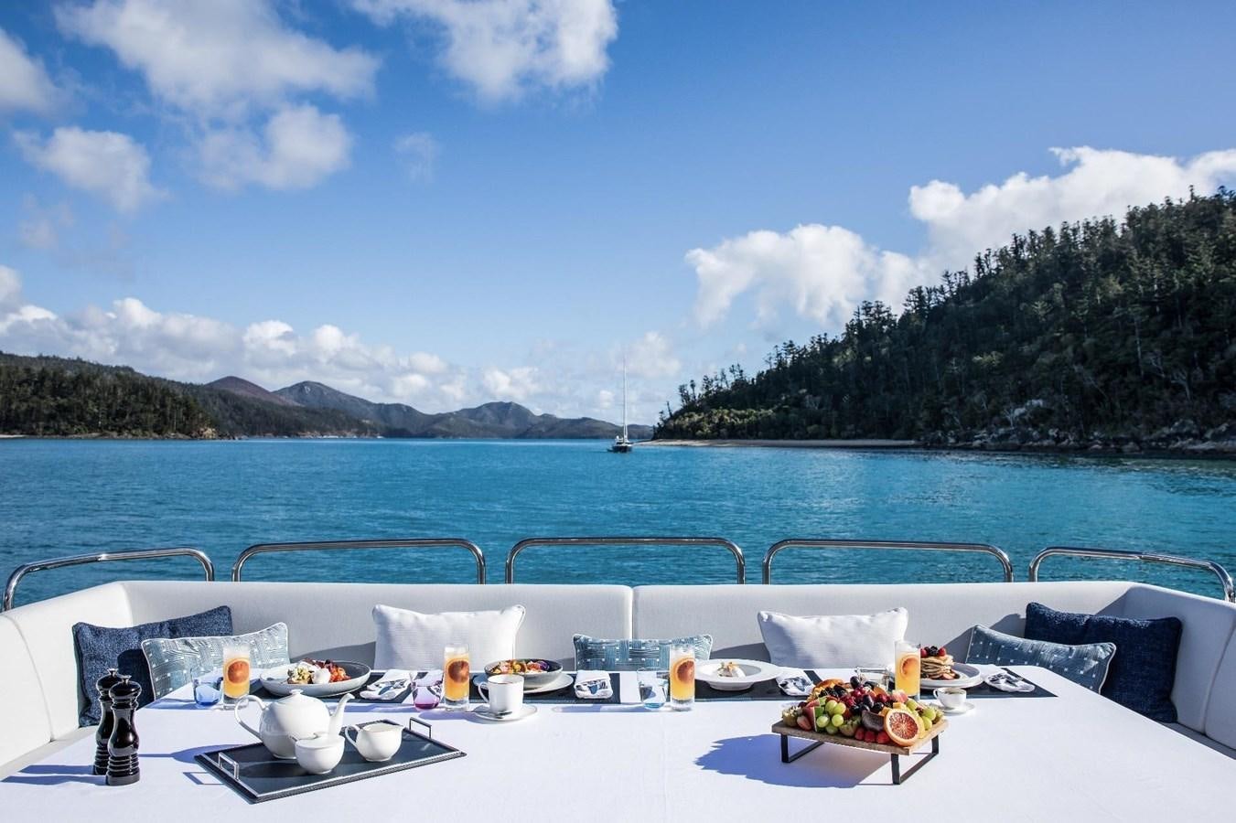 a table with food on it by the water aboard GEORGE P Yacht for Sale