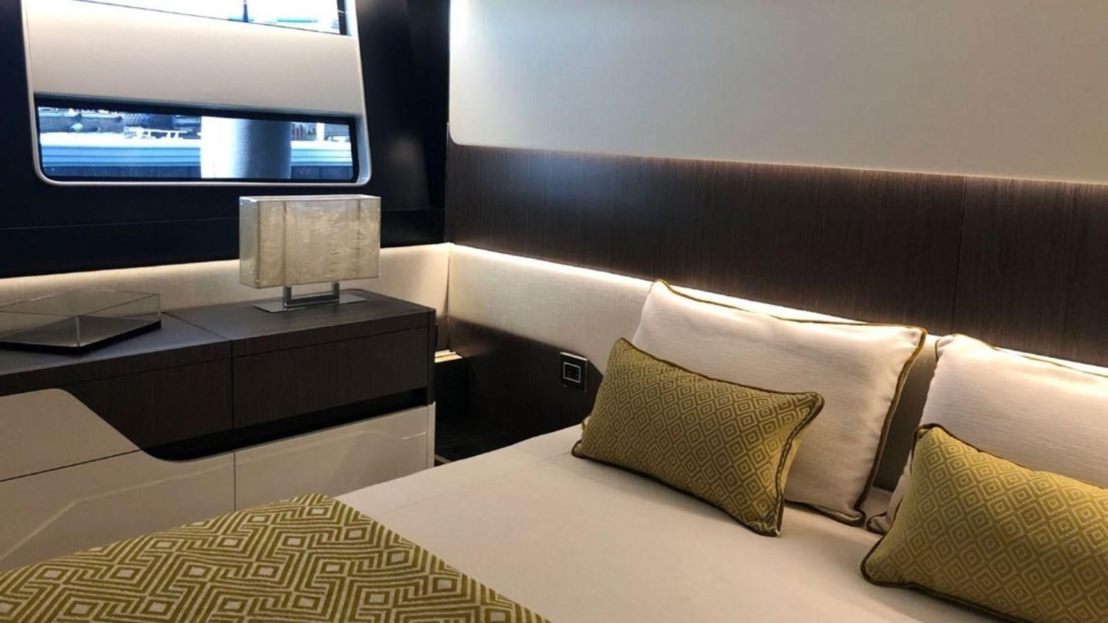 a bed with pillows and a television in the background aboard IN SIX Yacht for Sale