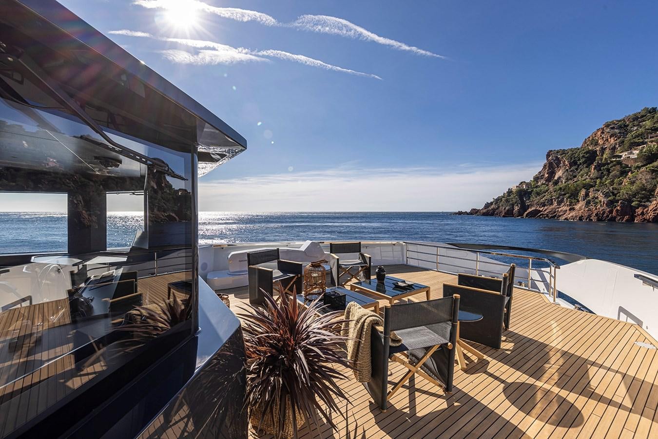 a deck with chairs and tables on it by the water aboard ARCADIA 96 Yacht for Sale