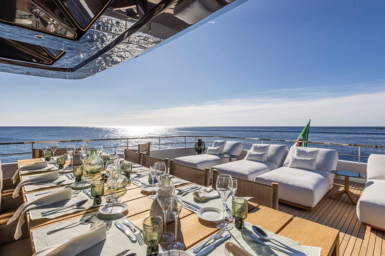 a table set for a meal on a balcony overlooking the ocean aboard ARCADIA 96 Yacht for Sale