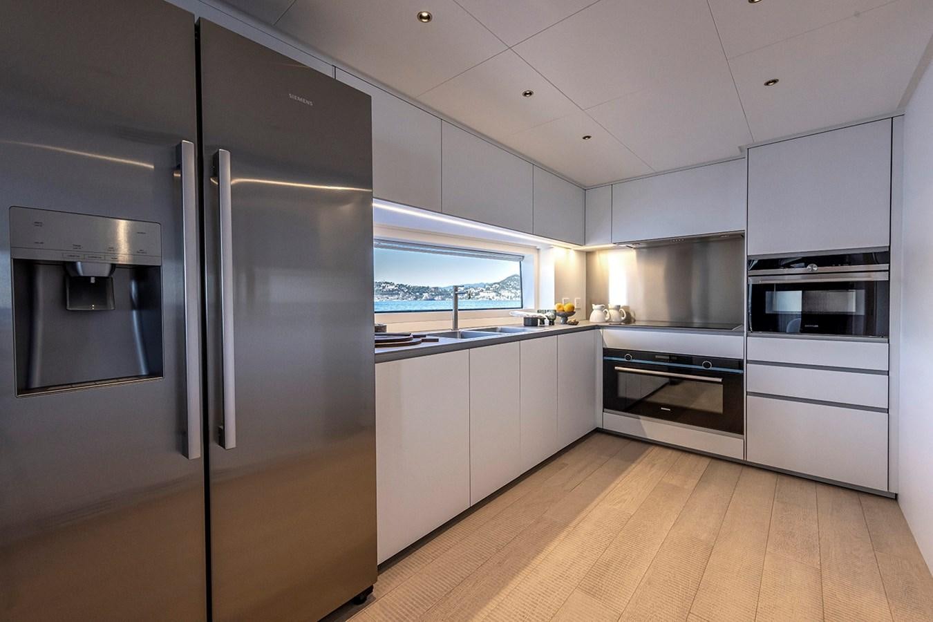 a kitchen with white cabinets aboard ARCADIA 96 Yacht for Sale