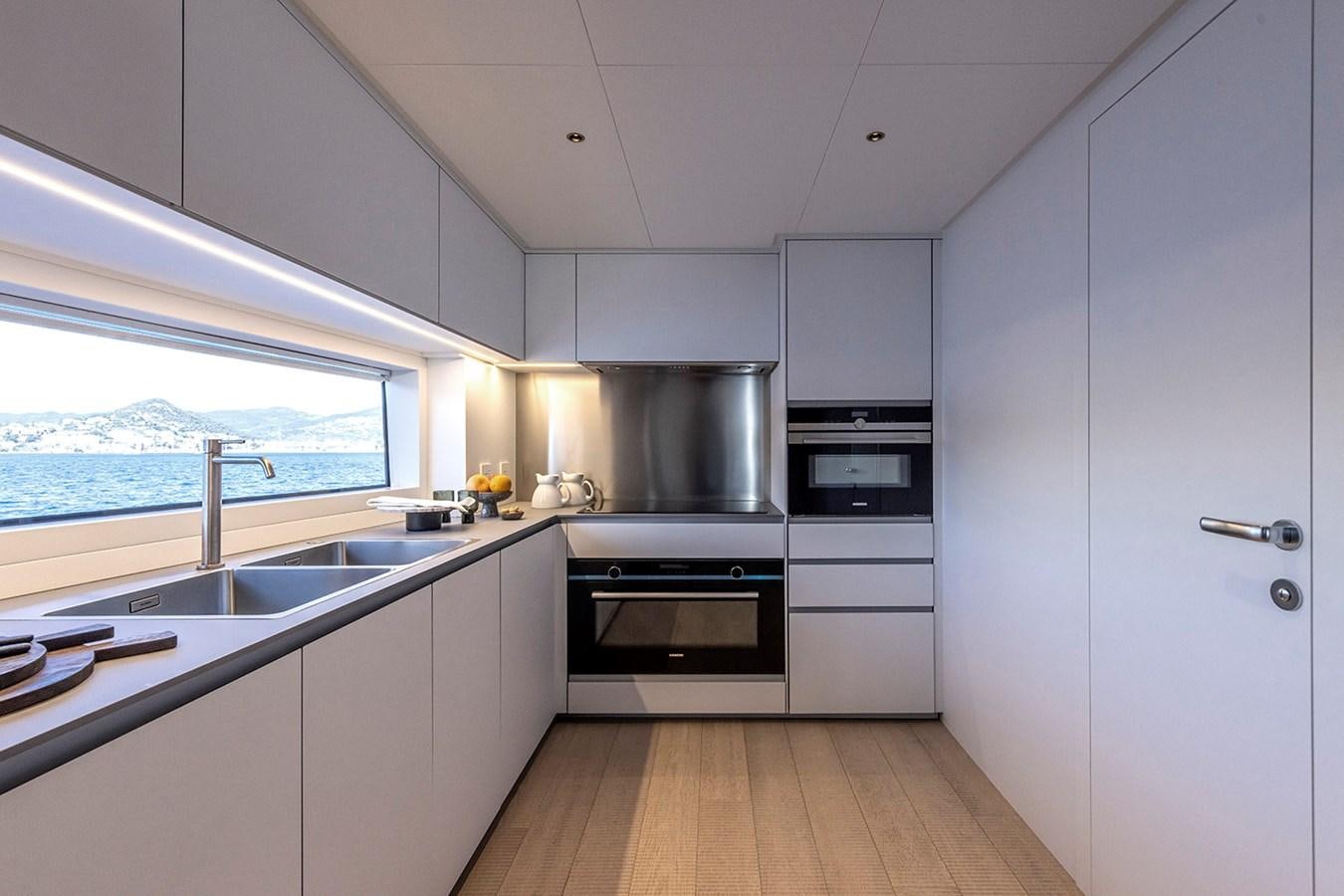 a kitchen with white cabinets aboard ARCADIA 96 Yacht for Sale