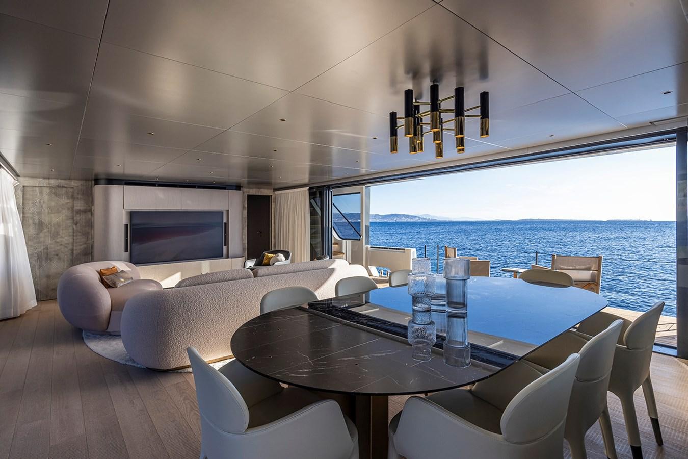 a room with a table chairs and a television aboard ARCADIA 96 Yacht for Sale