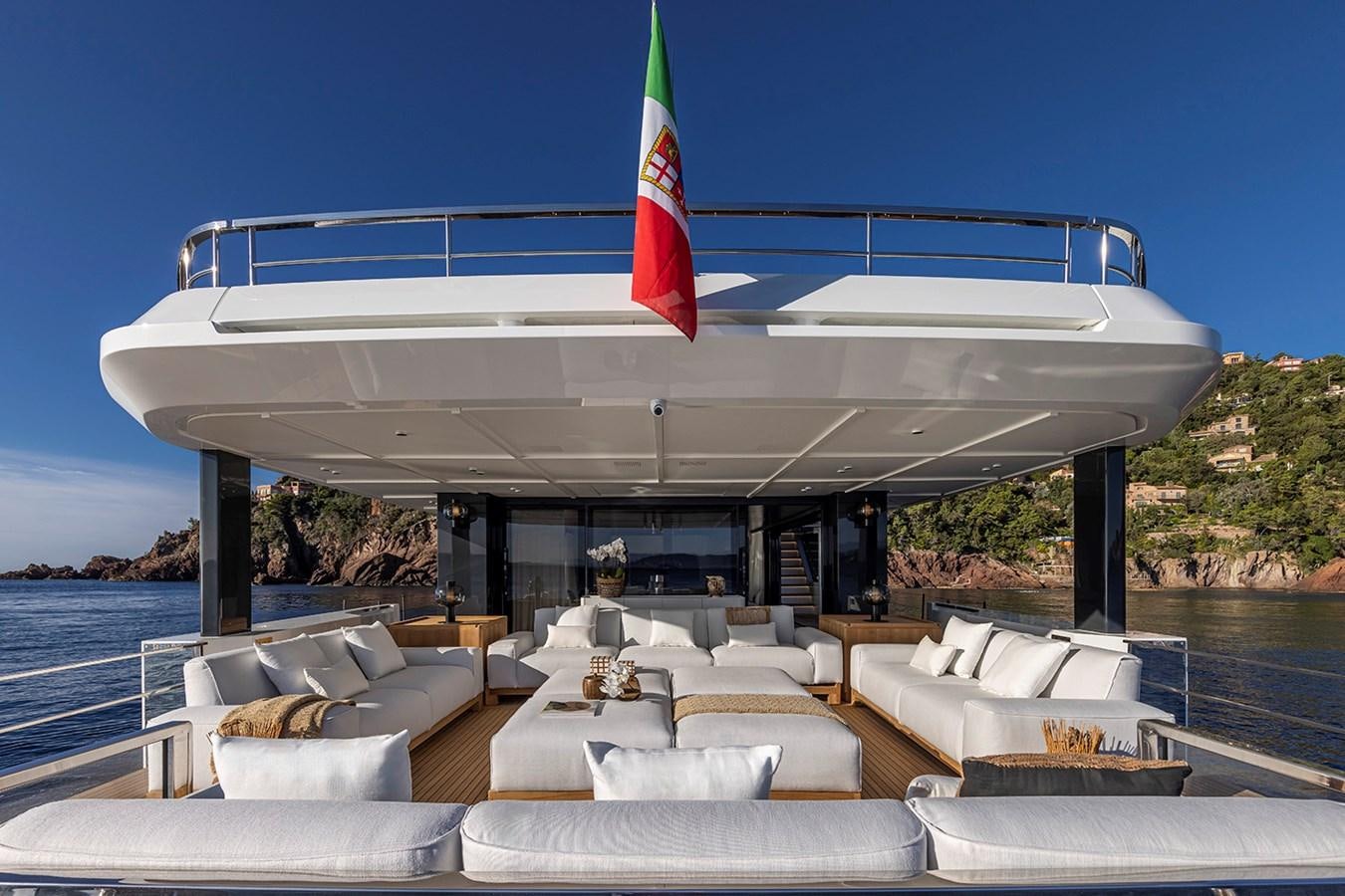 a large lounge area with a large white building with a flag on top aboard ARCADIA 96 Yacht for Sale