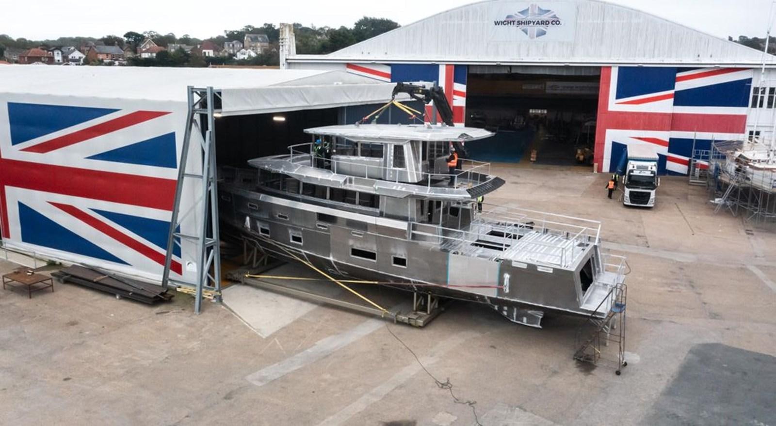 a large white boat with a flag on it aboard 2024 ARKSEN 85 Yacht for Sale