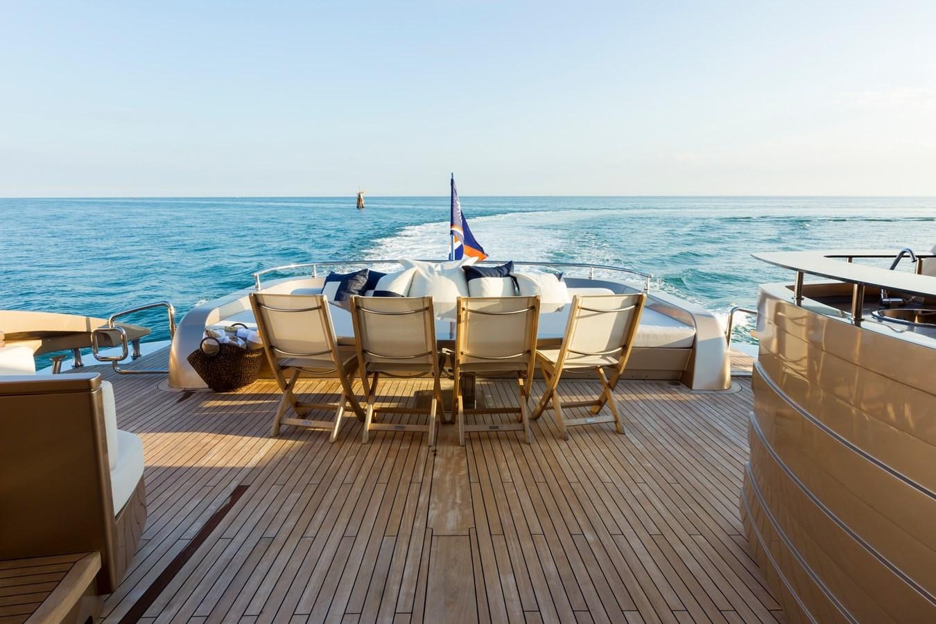 a deck with chairs and tables on it by the water aboard FIVE WAVES Yacht for Sale