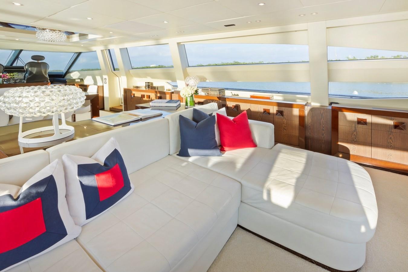 a room with white couches and a table with red pillows aboard FIVE WAVES Yacht for Sale