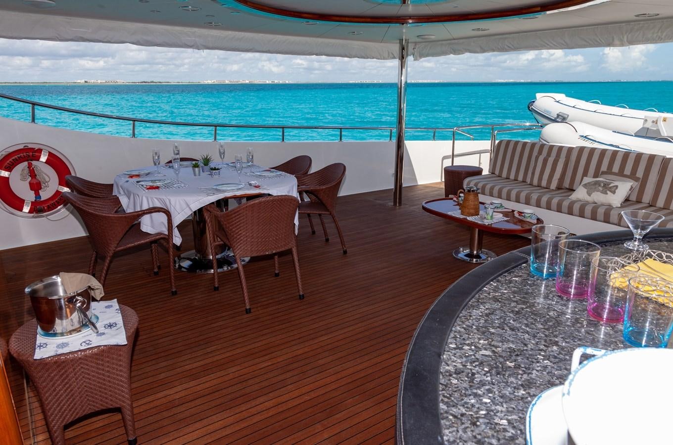 a patio with a table and chairs aboard SUNRISE Yacht for Sale