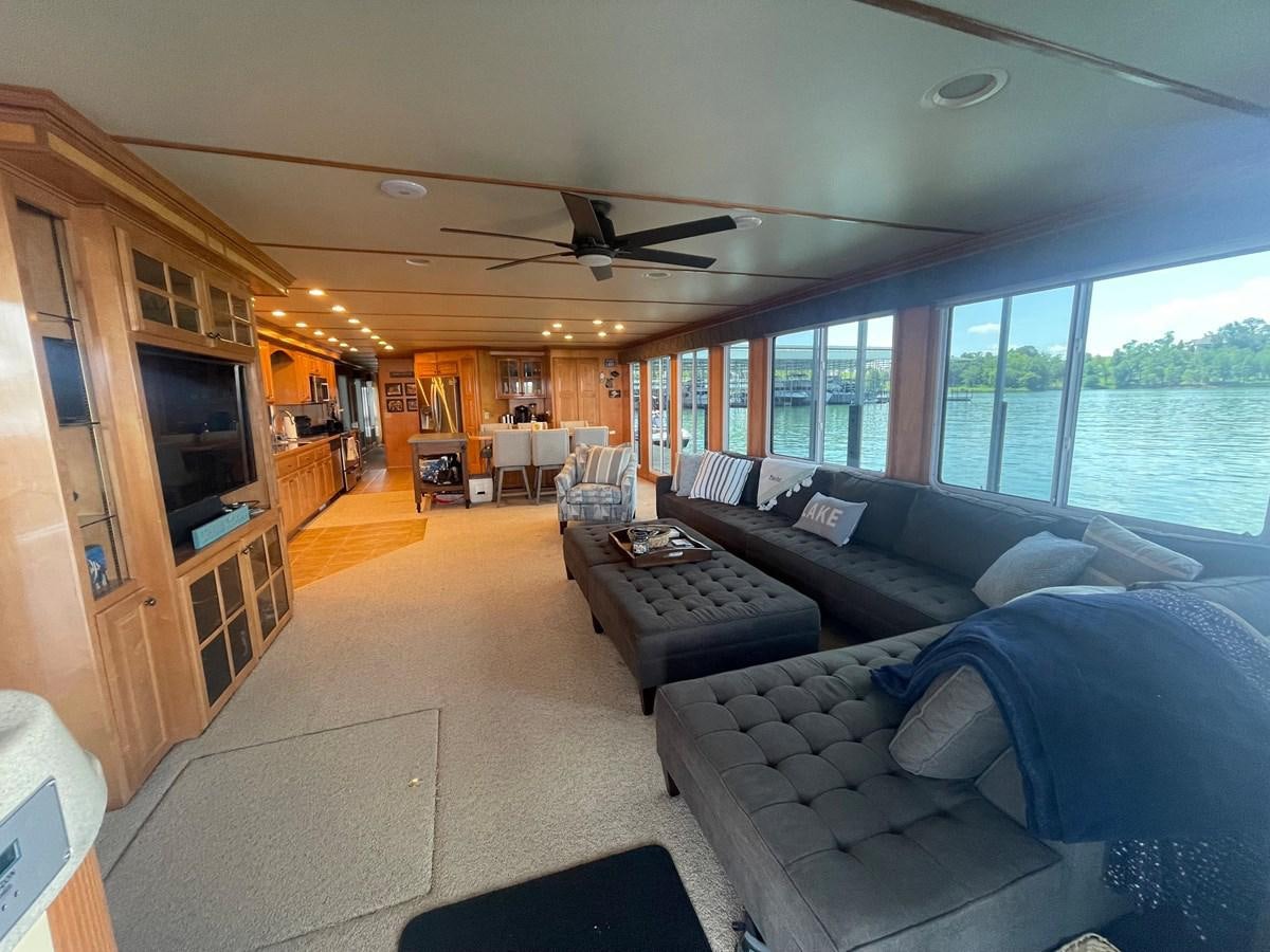 a living room with a large window aboard 2005 HORIZON 18X88 HOUSEBOAT Yacht for Sale