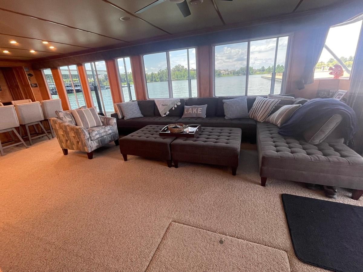a living room with a couch and a coffee table aboard 2005 HORIZON 18X88 HOUSEBOAT Yacht for Sale