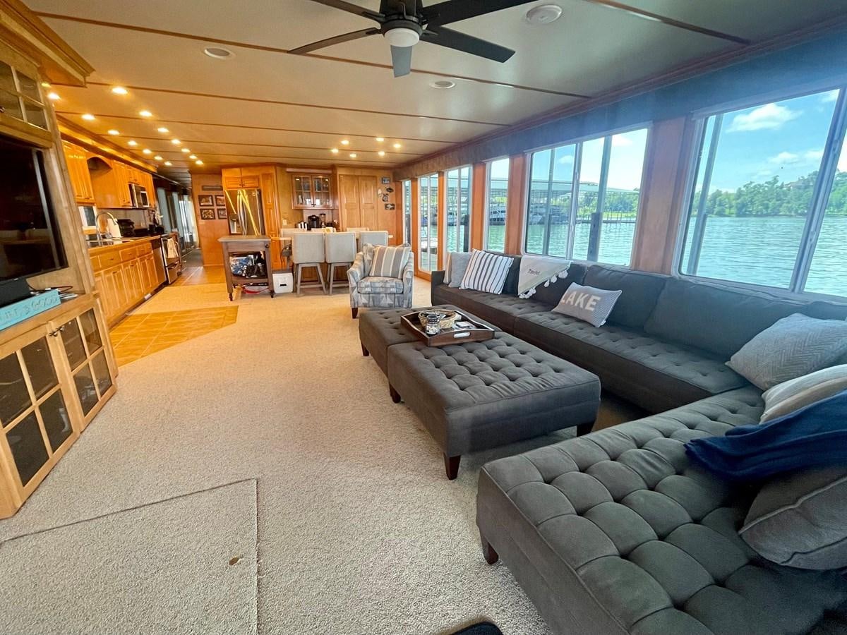 a living room with a large window aboard 2005 HORIZON 18X88 HOUSEBOAT Yacht for Sale