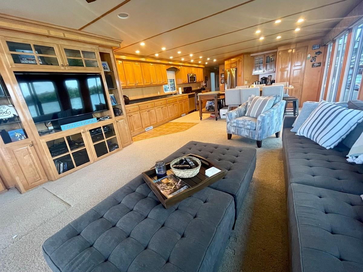 a living room with a couch and a coffee table aboard 2005 HORIZON 18X88 HOUSEBOAT Yacht for Sale