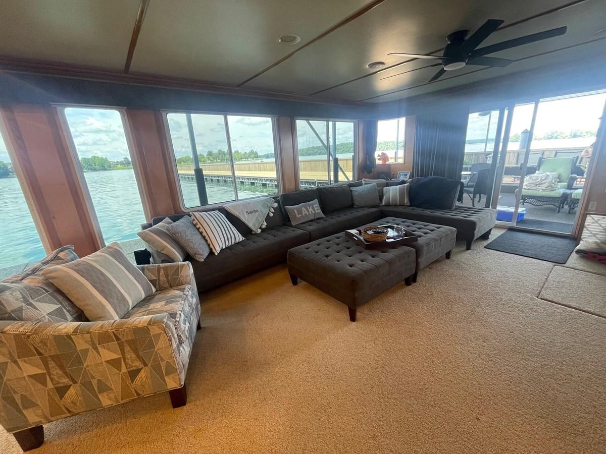 a living room with a large window aboard 2005 HORIZON 18X88 HOUSEBOAT Yacht for Sale